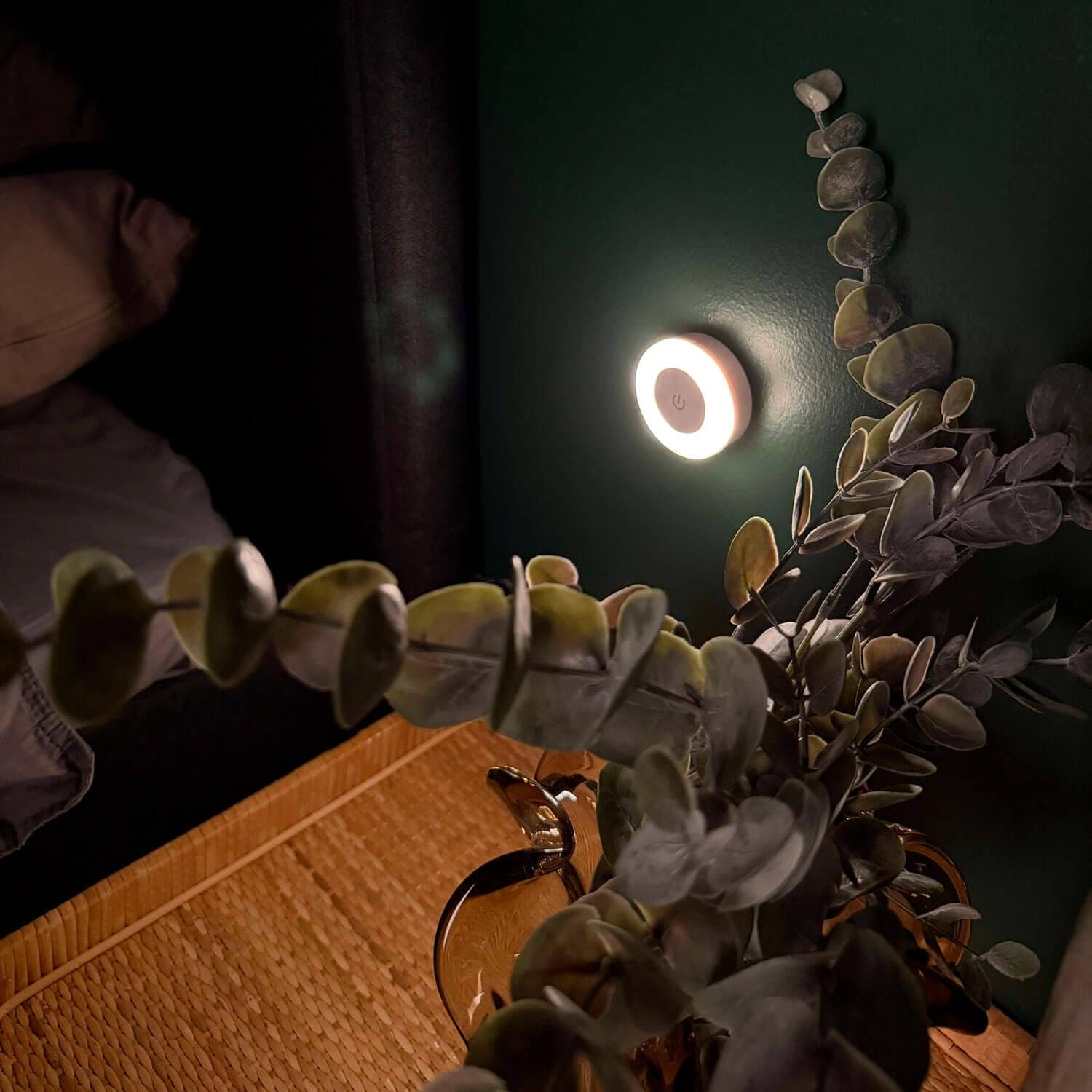 Rundes Stilllicht, das nachts die Wand neben dem Bett sanft beleuchtet